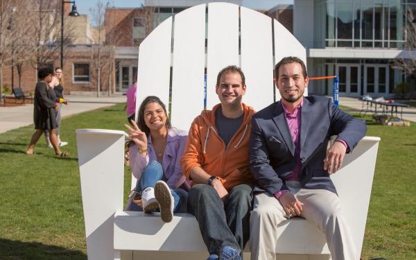Students in a large chair on the quad 